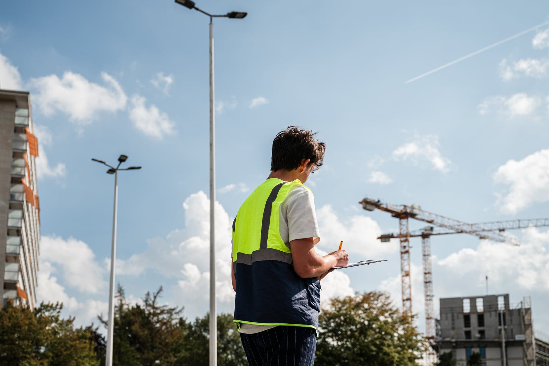 Werfhekken met wegwijzers naar parking, fietsenstalling en tramhalte bij een bouwproject