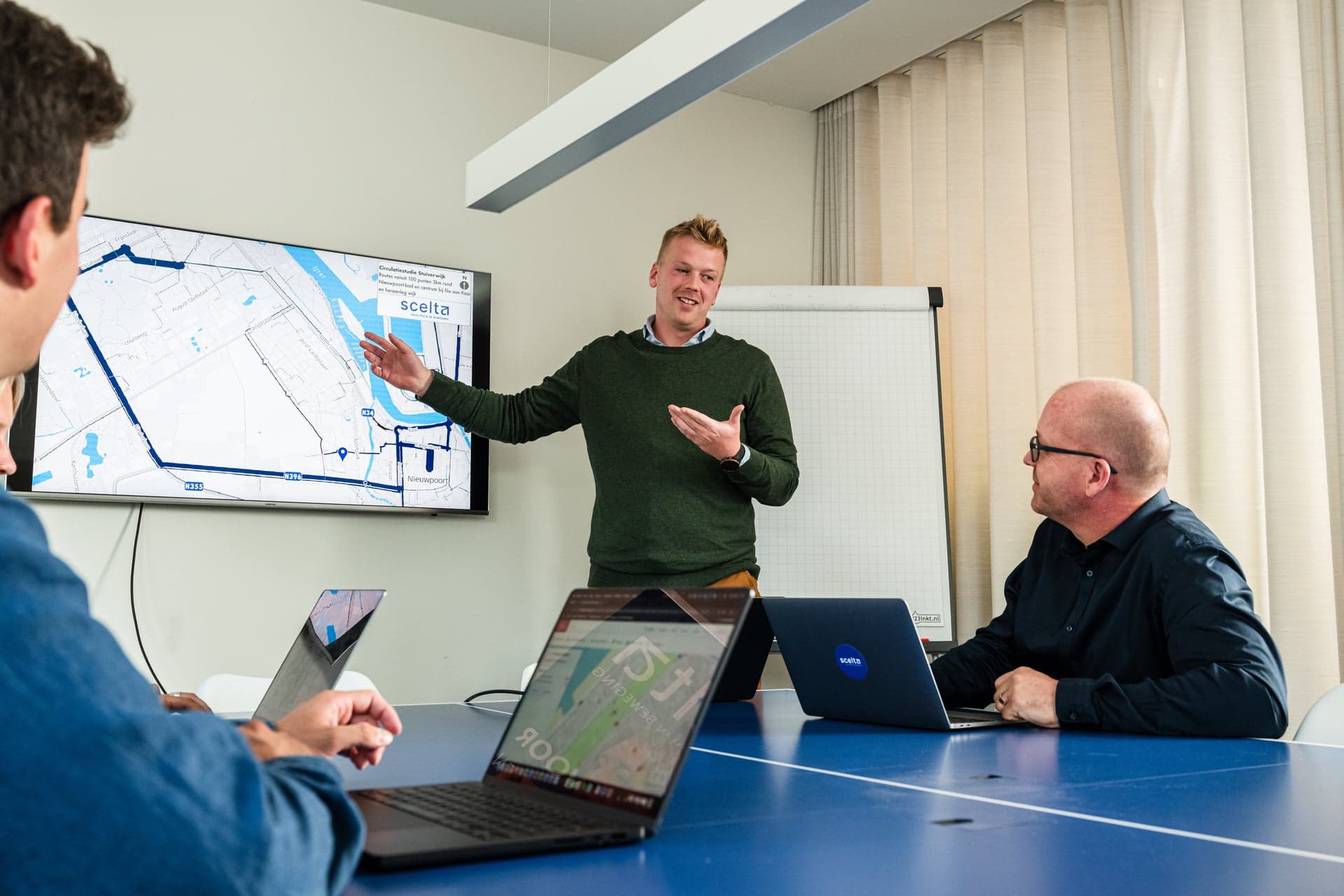 Een medewerker van Scelta geeft uitleg bij een mobiliteitskaart op het scherm