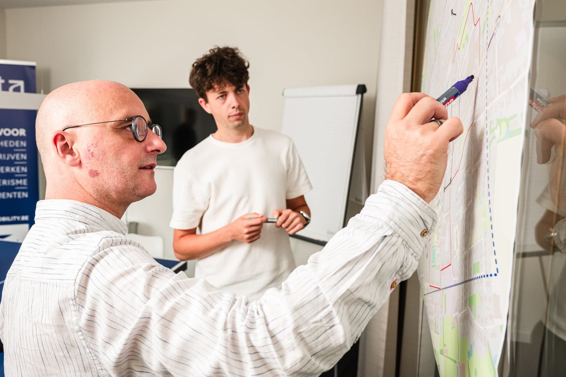 Een medewerker van Scelta duidt verkeersstromen aan op een kaart aan de wand