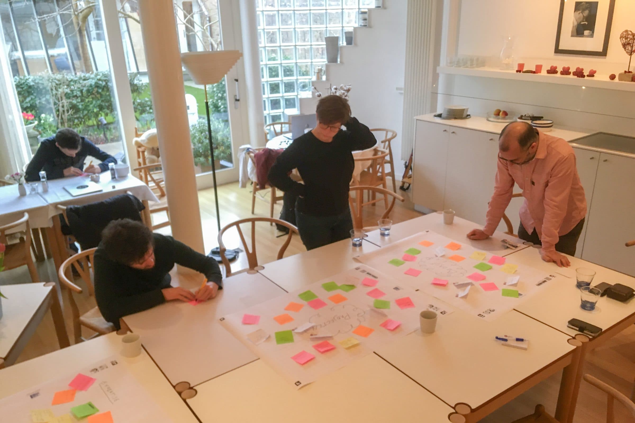 Collega’s werken samen aan een tafel vol post-its