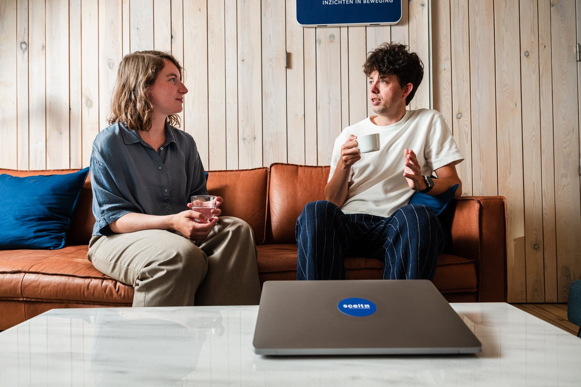 Twee collega’s van Scelta in gesprek met een kop koffie