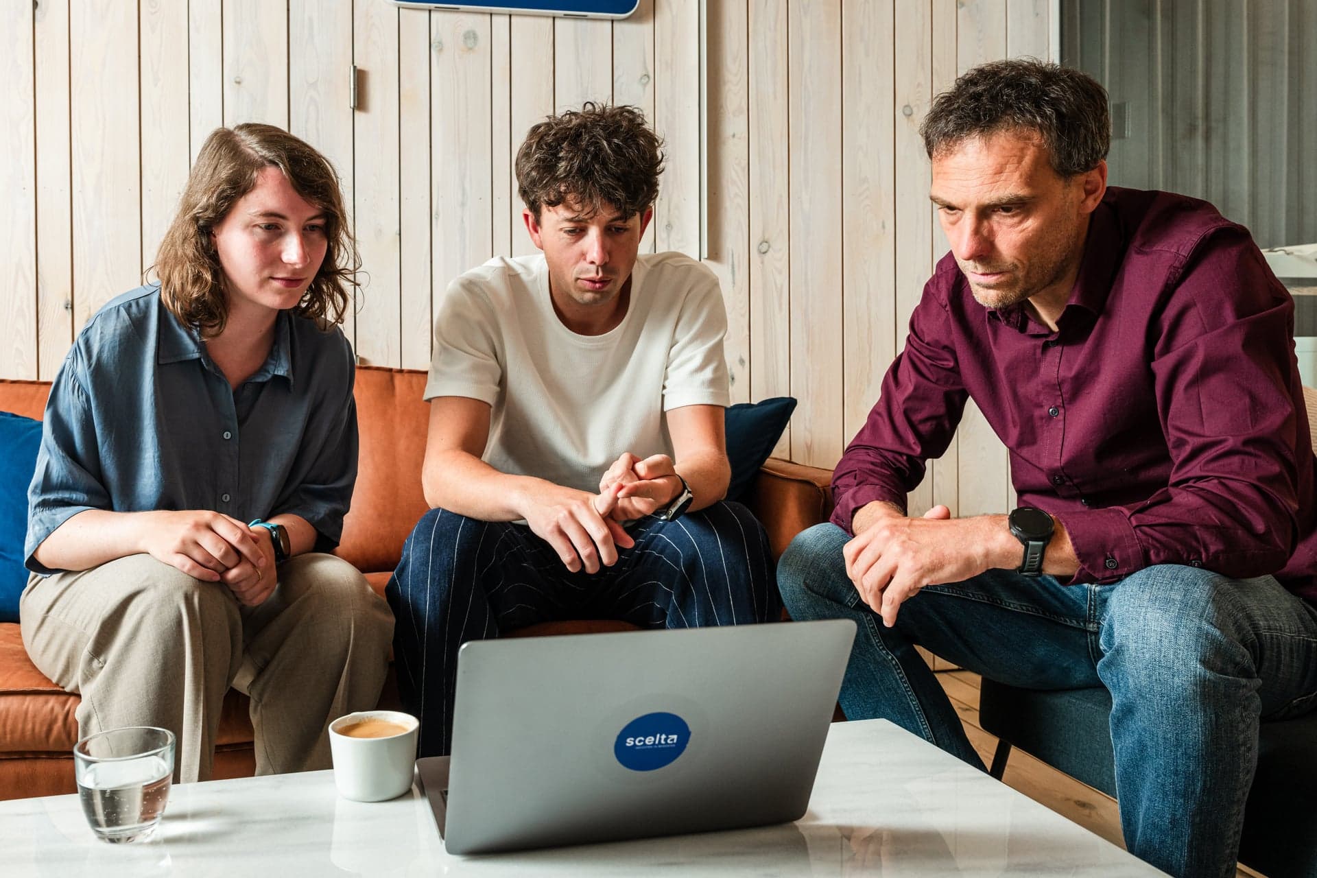 Drie collega’s van Scelta in gesprek in de zithoek van het kantoor