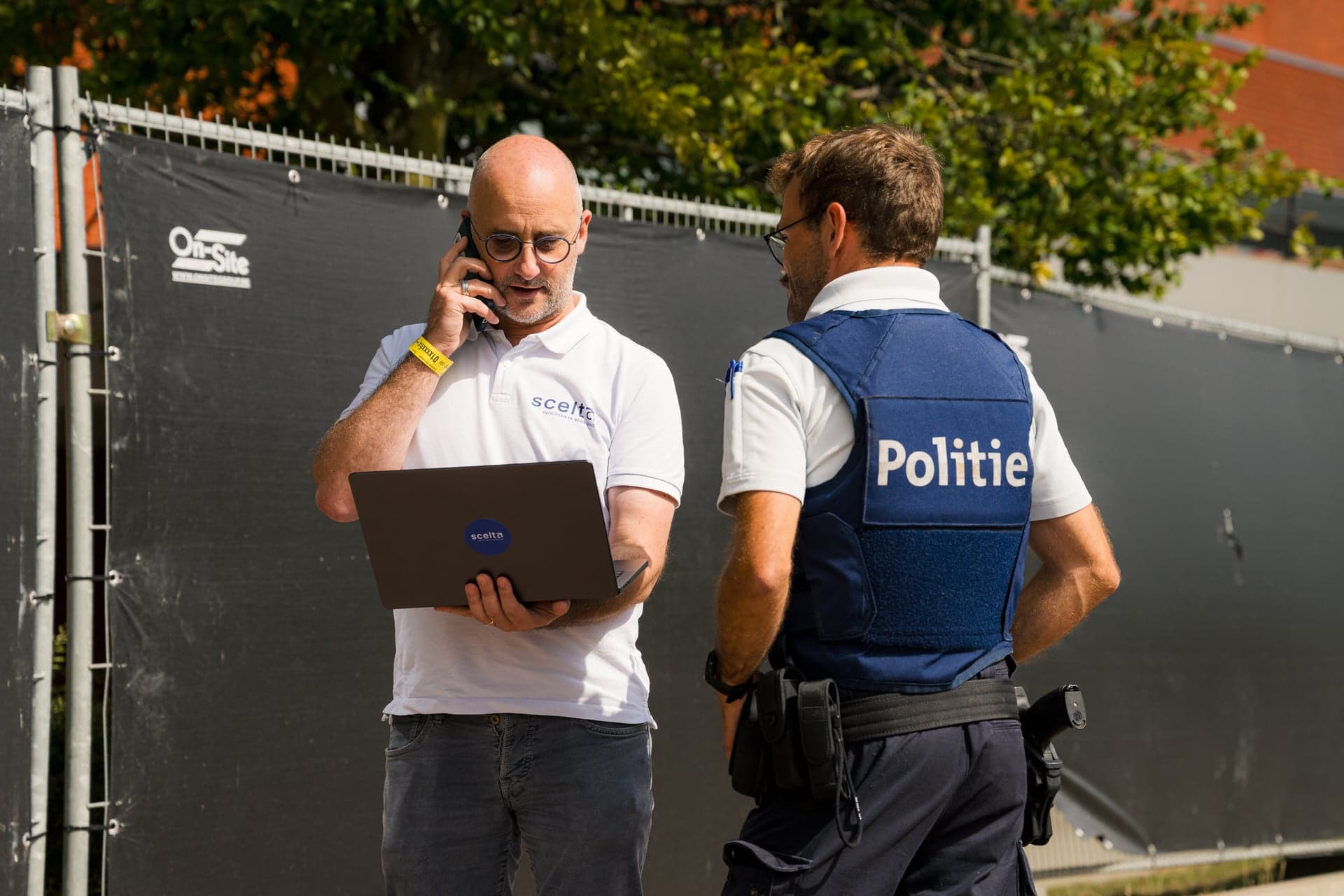 Een medewerker van Scelta overlegt met de politie aan de rand van een evenemententerrein