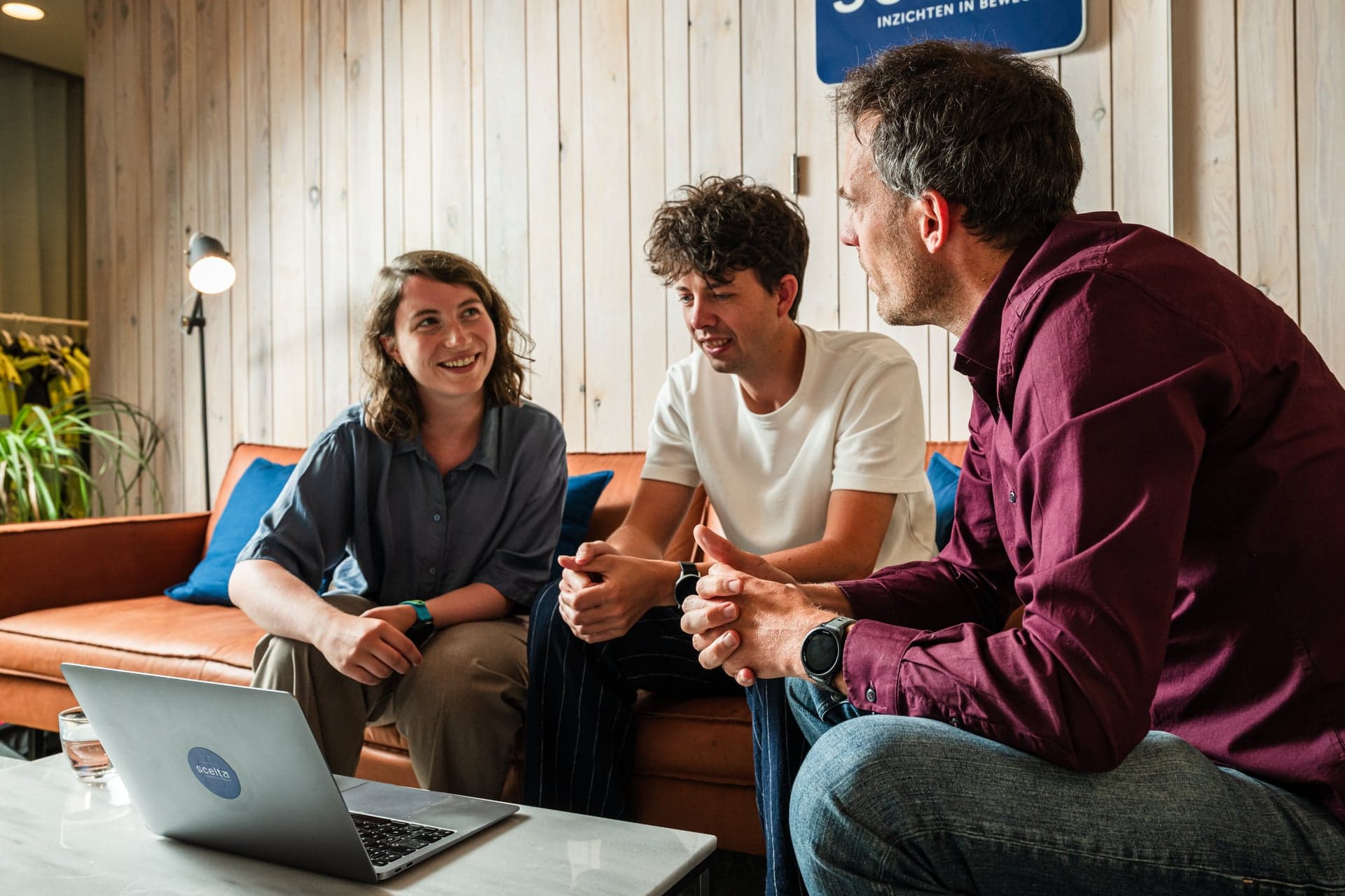 Collega’s van Scelta overleggen met een laptop in de zithoek van het kantoor